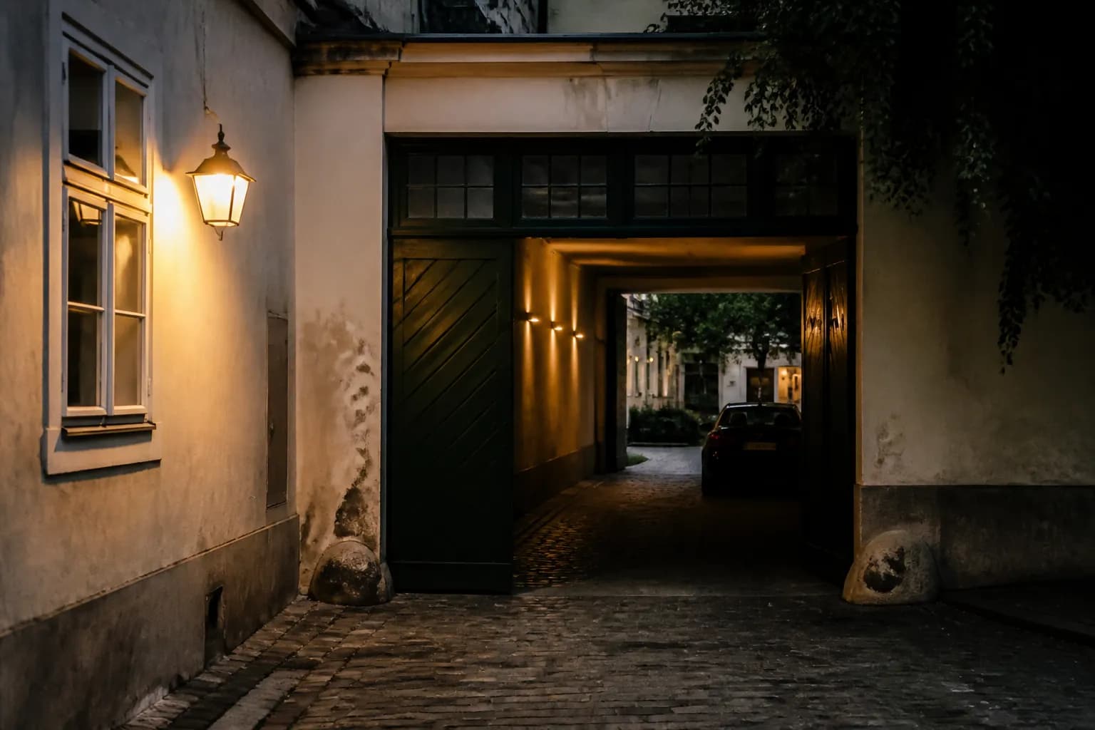 Hofeinfahrt eines Berliner Altbaus mit Stellplätzen im Innenhof, Abendlicht